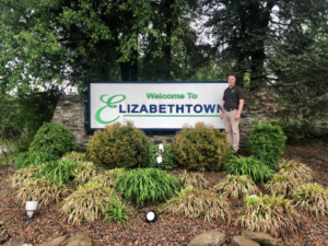Owner, Vince, posing next to Elizabethtown sign